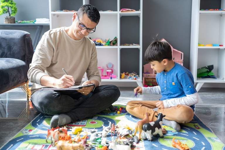 Social worker observing child playing with toys