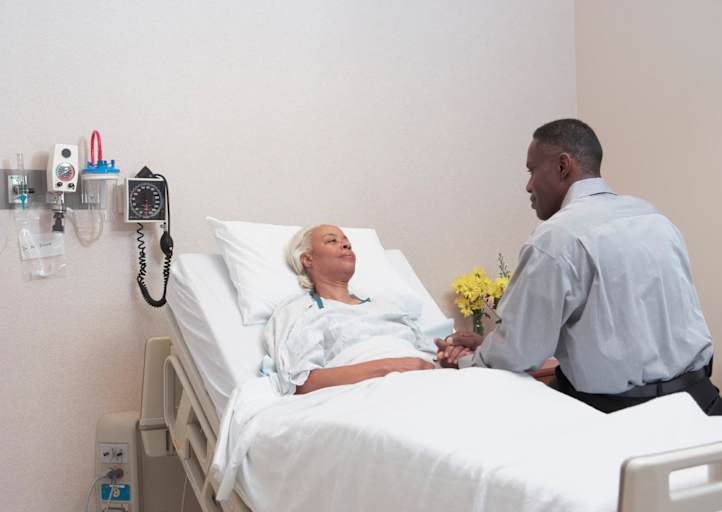 Hospital chaplain visiting patient in room