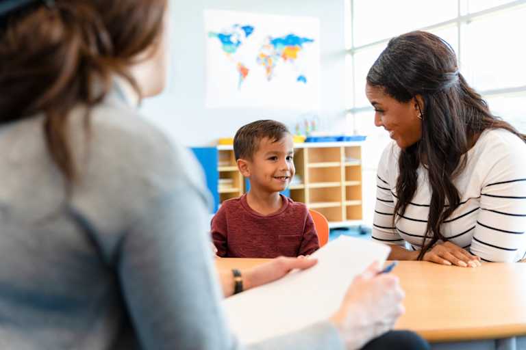 School counselor talking to young student in classroom